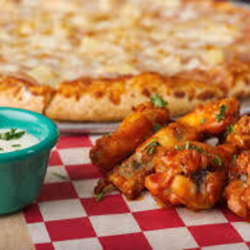 Gumby's Pizza cheese pizza, buffalo wings, and ranch dressing on a red and white checkered paper.